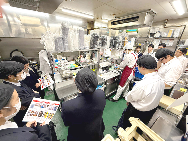 業平店のキッチンで調理の様子を見学する生徒の皆さん
