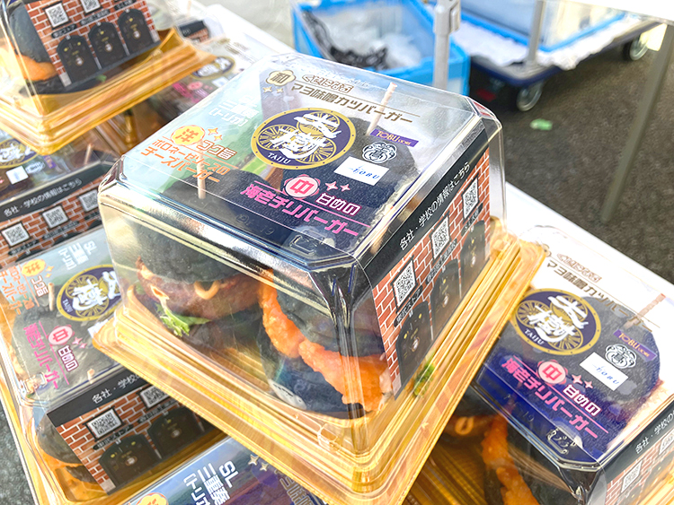 完成した「SL三重奏（トリオ）バーガー」。黒いバーガーの迫力が伝わるようにパッケージにもこだわっています。